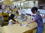 カウンター業務を体験中。元気にあいさつできるかな？（千種図書館　子ども図書館大使）