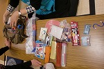 普通のショルダーバッグの中から防災グッズが続々出現(徳重図書館 緑区制50周年記念・防災講座「『いのちをまもる』おはなしと防災グッズ作り」)