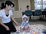 大きさを見ています。これでどうかな？（熱田図書館　「手づくり　カンタン　防災ずきん」）