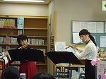 バックに本があり、図書館らしいです。（南図書館　南図書館開館５０周年企画「フロアコンサート　フルート・デュオ」）