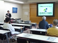 ビデオプロジェクターを使った講師の説明。（港図書館講演会「なごやの上下水道１００周年について」）