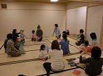 「うえからしたからおかぜこいこい...」きれいな布を使ってかぜをよびます。（徳重図書館　子どもと本の講座「わらべうたであそぼう」）