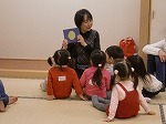 「おつきさまえらいの」のわらべうたに聞きいる子どもたち。（徳重図書館　「親子で楽しむ絵本とわらべうたの会」）