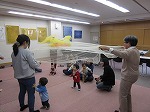 赤や黄色の布を落ち葉に見立てて。（港図書館　「子どもと本の講座　親子でたのしむ～季節のわらべうたとえほん」を行いました）