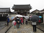 陽岳寺山門の前で。皆さん、ガイドの先生の説明に聞き入っています。（山田図書館　「＜蛇池・大乃伎＞史跡ウォーク」を行いました）