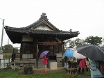 蛇池神社の前で。このころには雨が本降りになってきました。（山田図書館　「＜蛇池・大乃伎＞史跡ウォーク」を行いました）