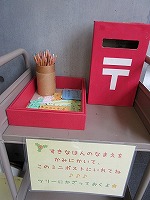 ここにある紙にすきな本の名前を書いて、このミニポストに入れておいてね。（みなと図書館　おすすめ本のツリー）