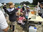 矢田川の水と水道水の透明度をくらべています。（もりやま図書館　「第5回矢田川自然体験学習」）