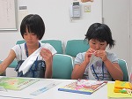 本の装備のお仕事です。真剣です！（なかがわ図書館　「子ども図書館大使」）