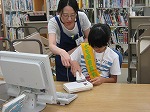 第3回　カウンターでバーコードをピッ！となぞります。（めいとう図書館　「子ども図書館大使」）