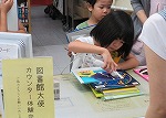 カウンターできんちょうしながら本の貸出をしました。（てんぱく図書館　「子ども図書館大使」）