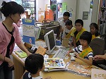 初めてのカウンター体験の仲間を見守る大使たち。（とみだ図書館　「子ども図書館大使」）