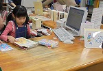 本がいっぱい！ぜんぶバーコードをなぞります。（きた図書館　「なごやっ子読書ノートでカウンター体験」）