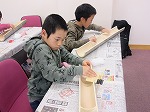 一弦琴の竹にやすりをかけます。（みなと図書館　「世界の楽器を作って一緒にあそぼう」をおこないました）