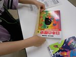 南陽図書館「なごやっ子読書ノートで図書館お仕事」本にフィルムカバーをかけている写真